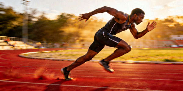 田径运动员在跑道上冲刺的瞬间，背景虚化